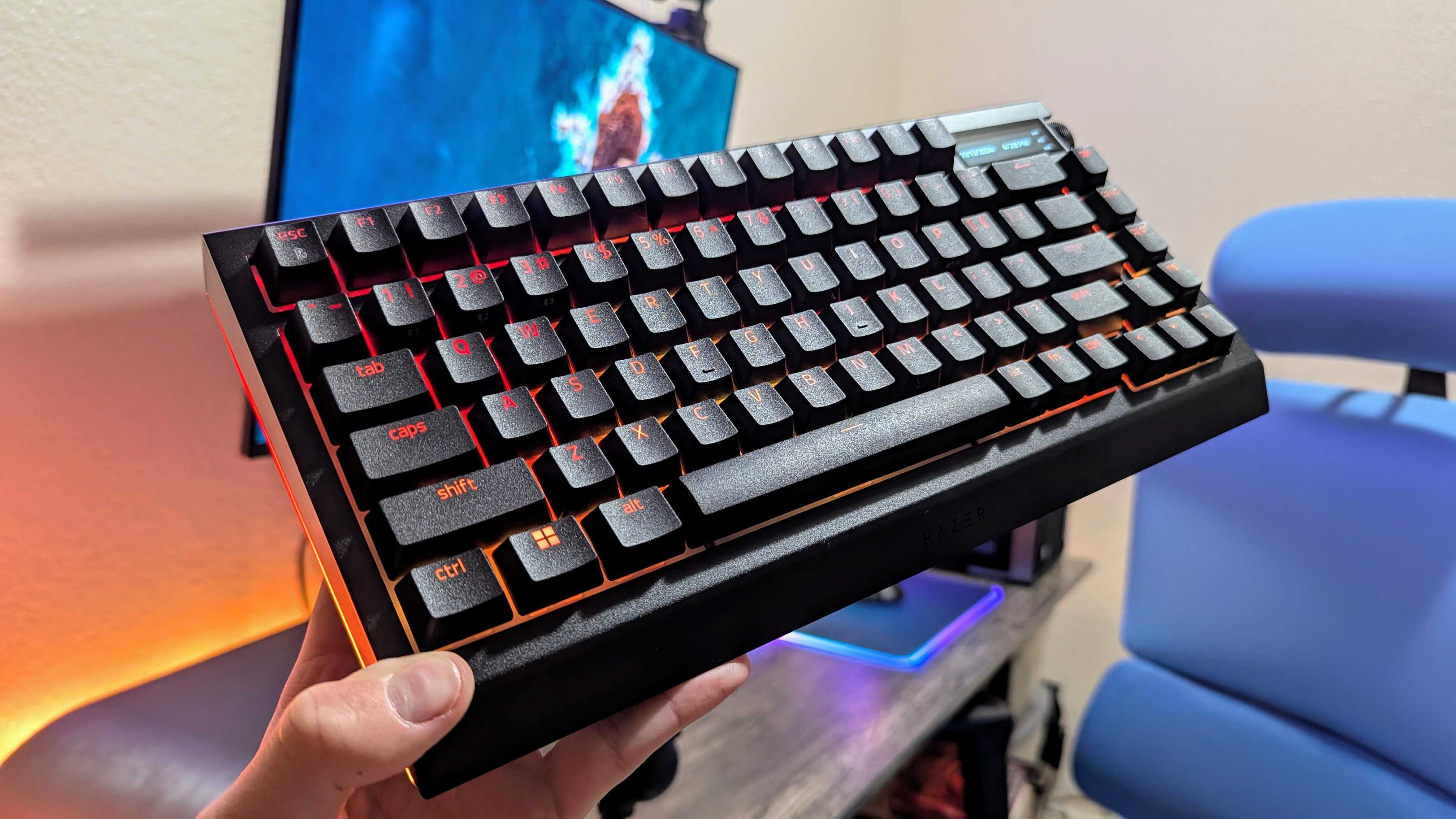 The Razer BlackWidow V4 Pro 75% held up by a hand.