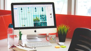 best computers for graphic design: iMac on desk with keyboard and pot plant