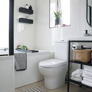 Black and white bathroom with black shelves and black framed vanity unit