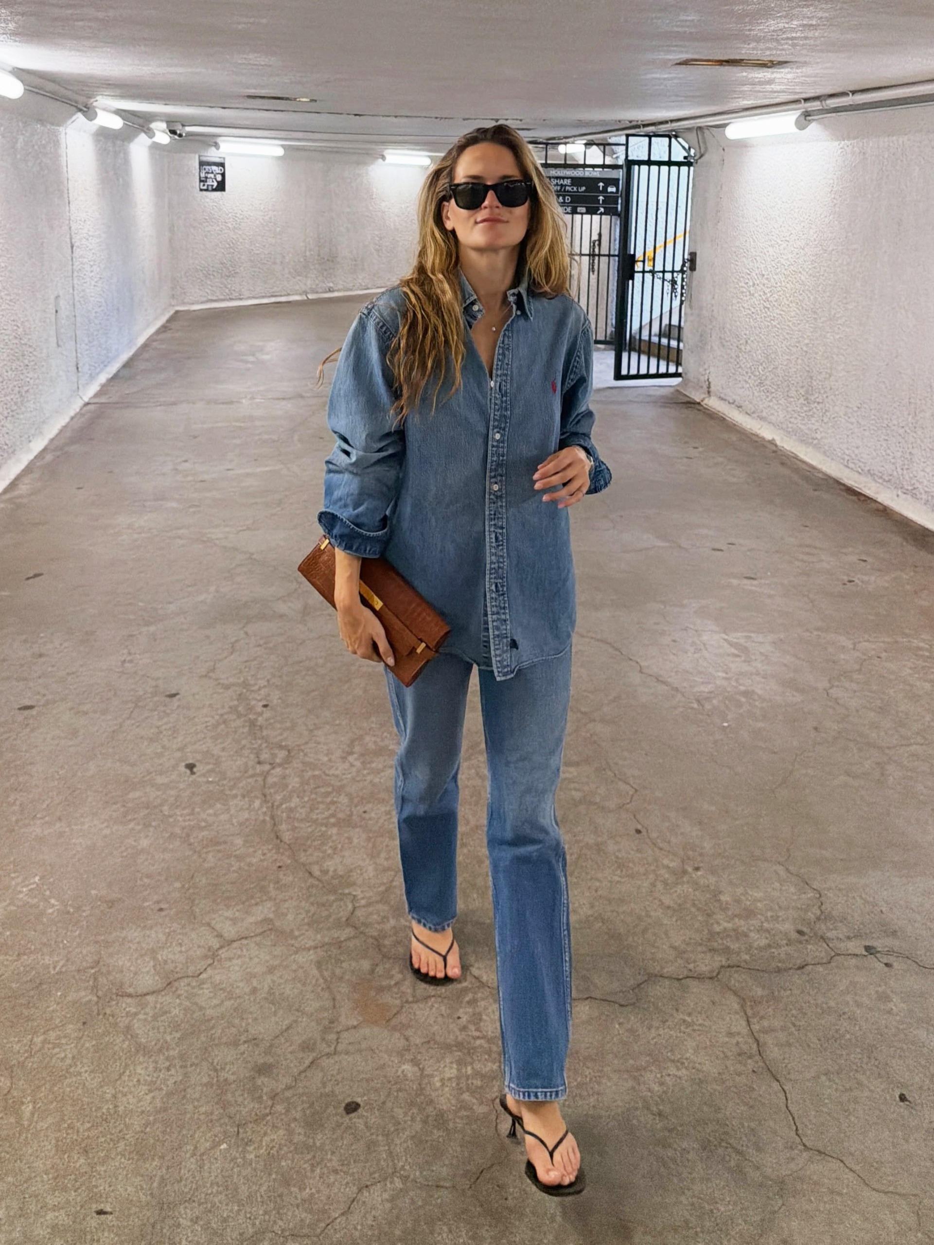 Stylish woman wearing jeans, a denim shirt, and high-heel flip-flops