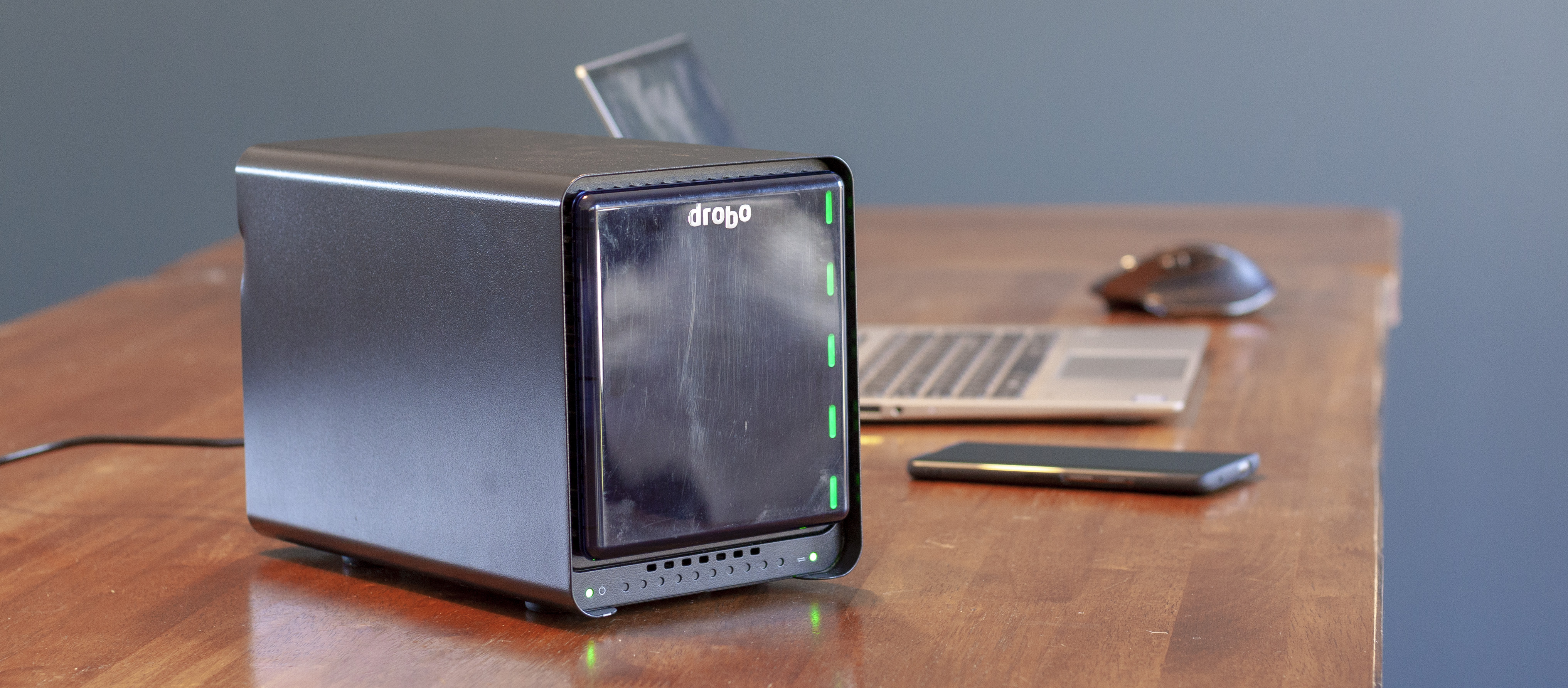 Drobo 5N2 på et bord med en laptop i bakgrunnen