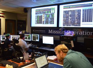 Flight controllers (from left) Katie Bechtold, Ed Colwell and Jon Van Eck, working in the mission operations center at the Johns Hopkins Applied Physics Laboratory in Laurel, Maryland, confirm data indicating that the New Horizons spacecraft had safely exited hibernation on Sept. 11, 2017. 