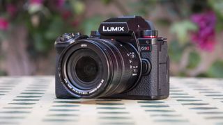 Panasonic Lumix G9 II camera on a patterned table with pink flower background