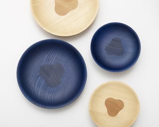 Wooden bowls shot from above in natural and blue stained wood against a white background