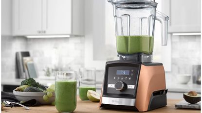 Best Vitamix Black Friday deals include the Vitamix A3500 Ascent Series Blender, pictured on a countertop with green juice inside and infront of it