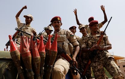 Sudan's paramilitary Rapid Support Forces soldiers greet people as they secure a site in Khartoum.
