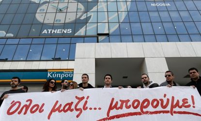 Employees of the Athens, Greece Bank of Cyprus rally in solidarity with the struggling island country.