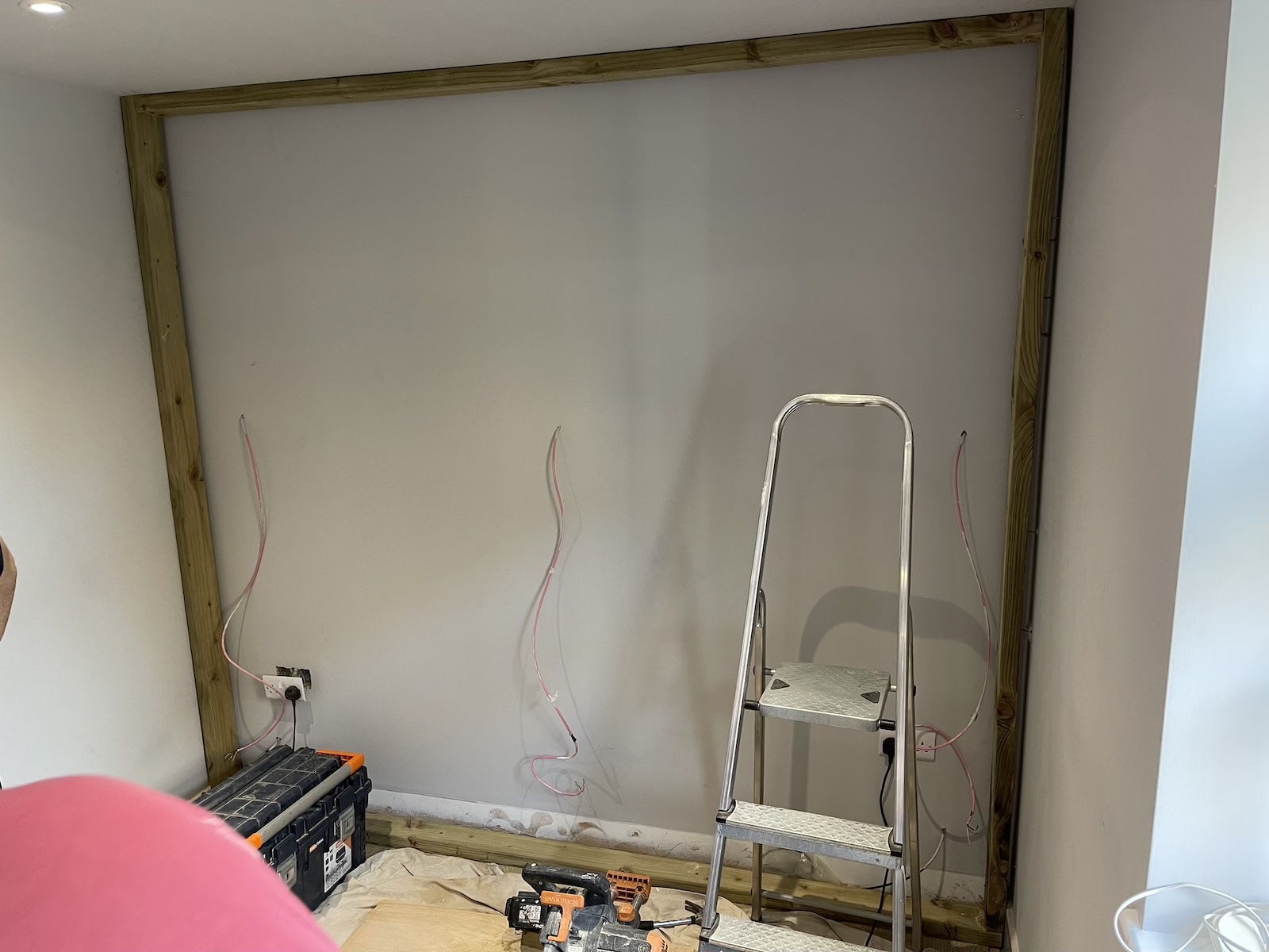 An image of a stud wall being constructed for three in-wall speakers to be embedded