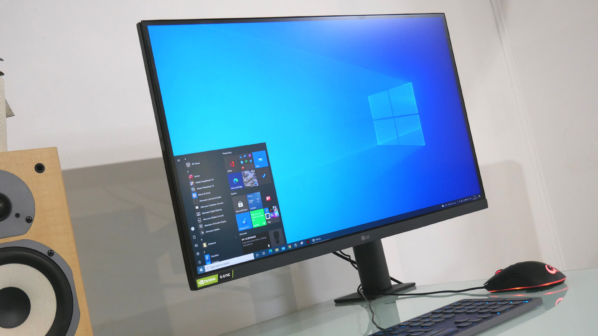 En LG UltraGear Ergo 27GN88A står på ett skrivbord och visar den blå original-hemskärmen.