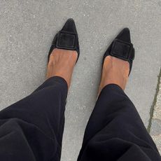 Photo of woman from above wearing black jeans and simple black mules.