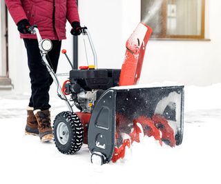 Closeup of red snow blower in action