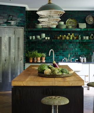 Green kitchen color ideas with a wall of subway tiles, wooden butchers block-style kitchen island and white and steel accents.