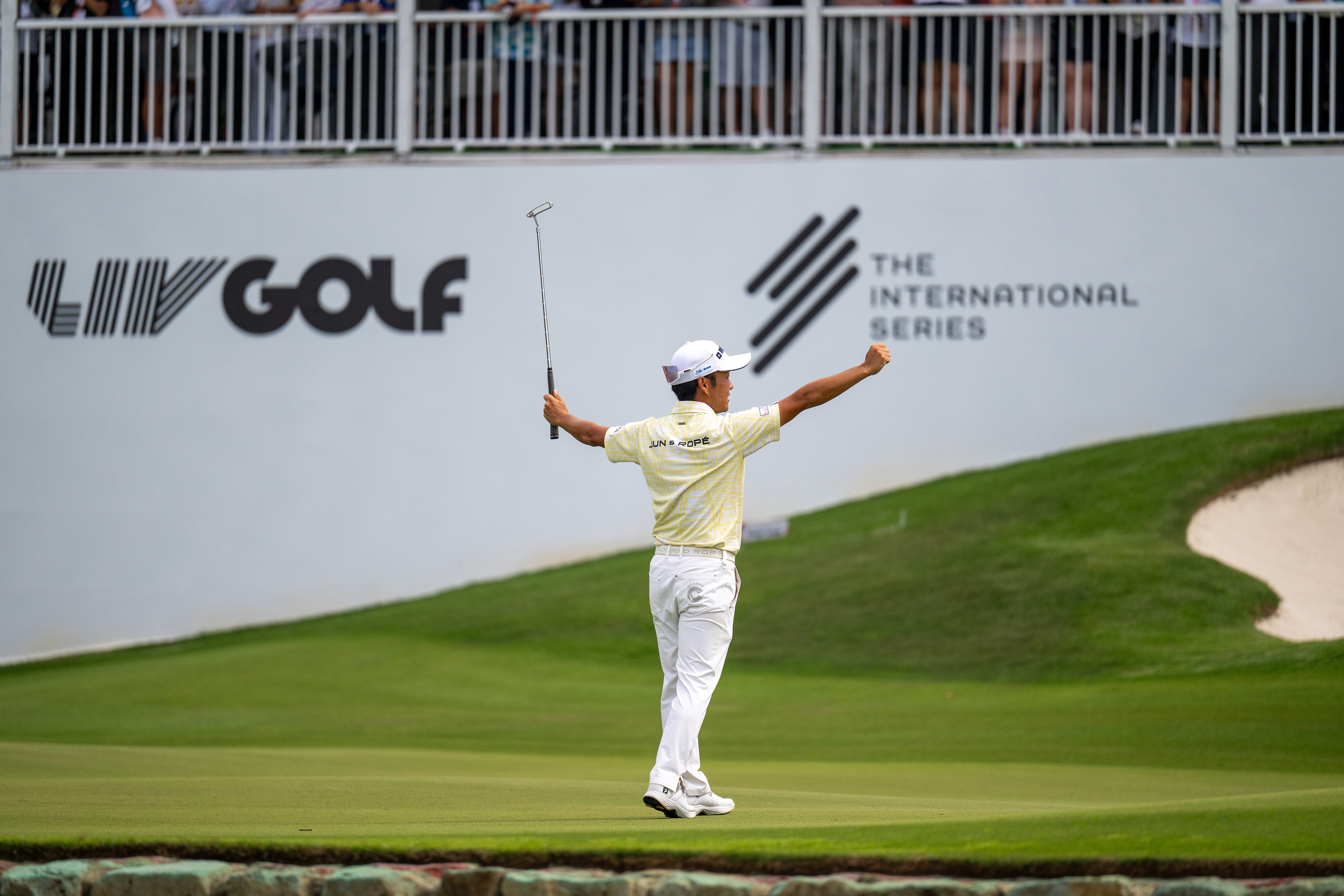 Yosuke Asaji celebrates after rolling in a putt