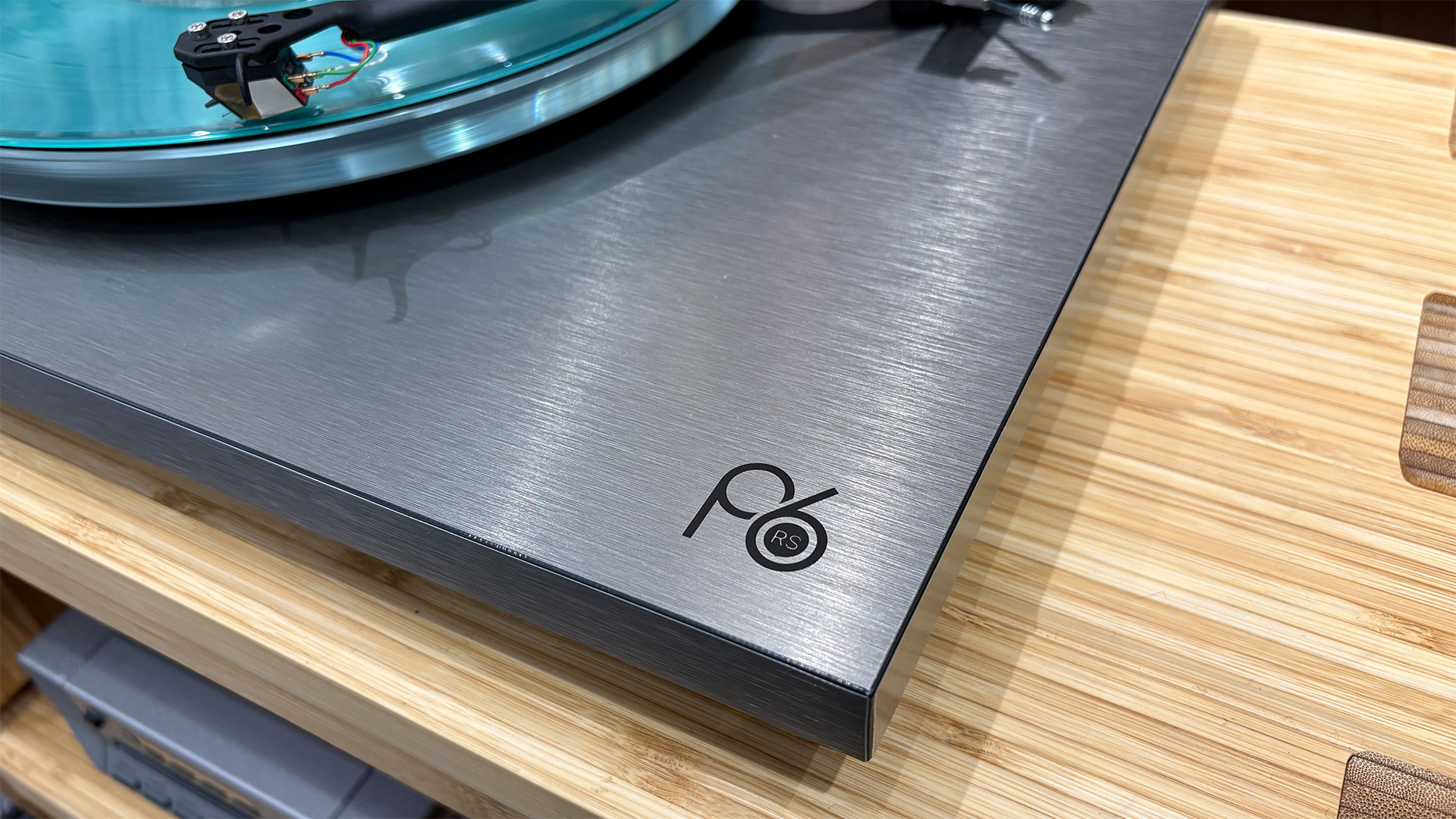Rega Planar 6 RS Edition turntable on wooden hi-fi rack showing P6 logo on bottom right of plinth