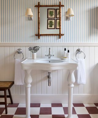 bathroom striped wallpaper with a traditional vanity with red and white checkerboard tile