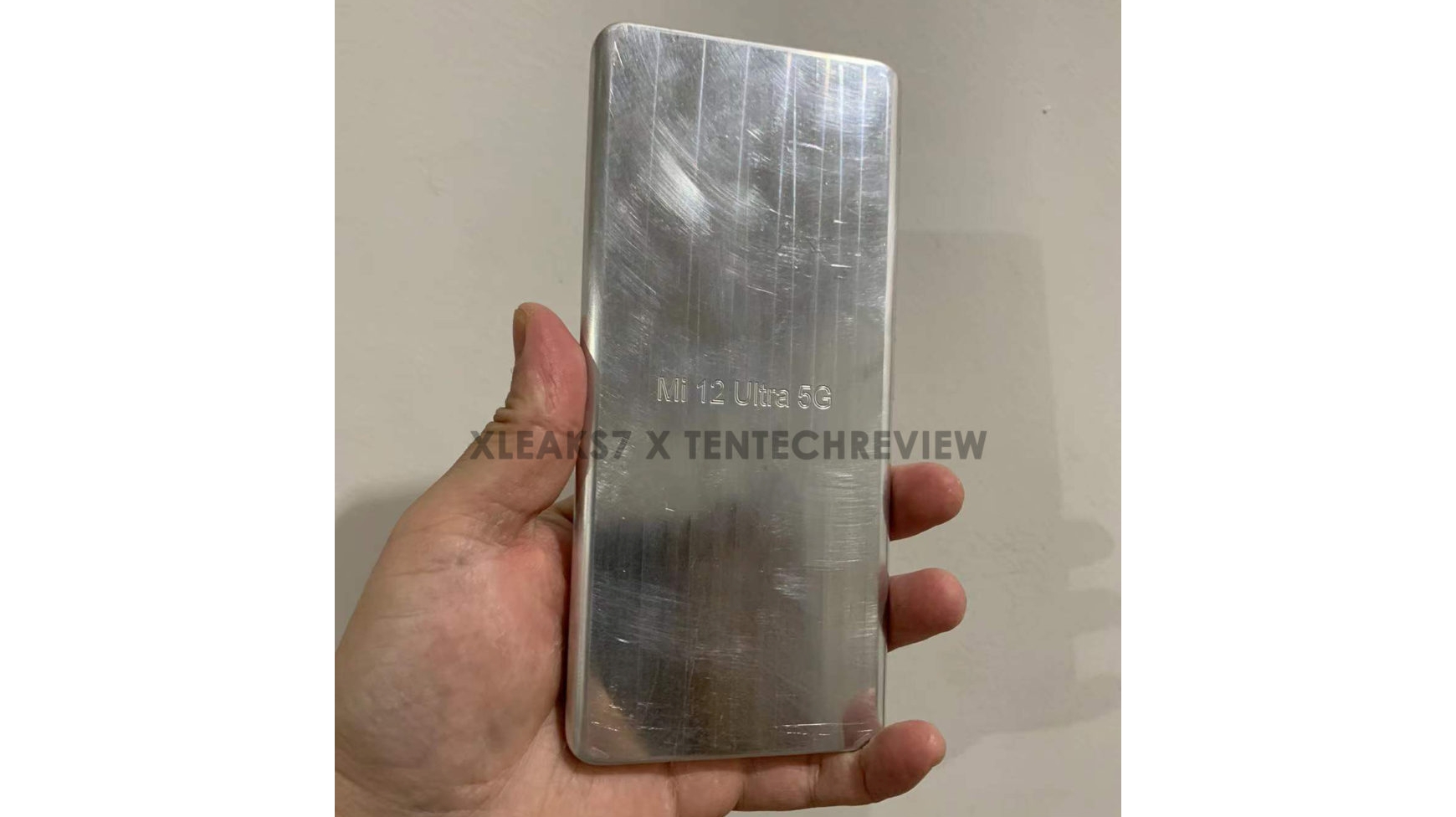 An aluminum dummy unit of the Xiaomi 12 Ultra held in someone's hand