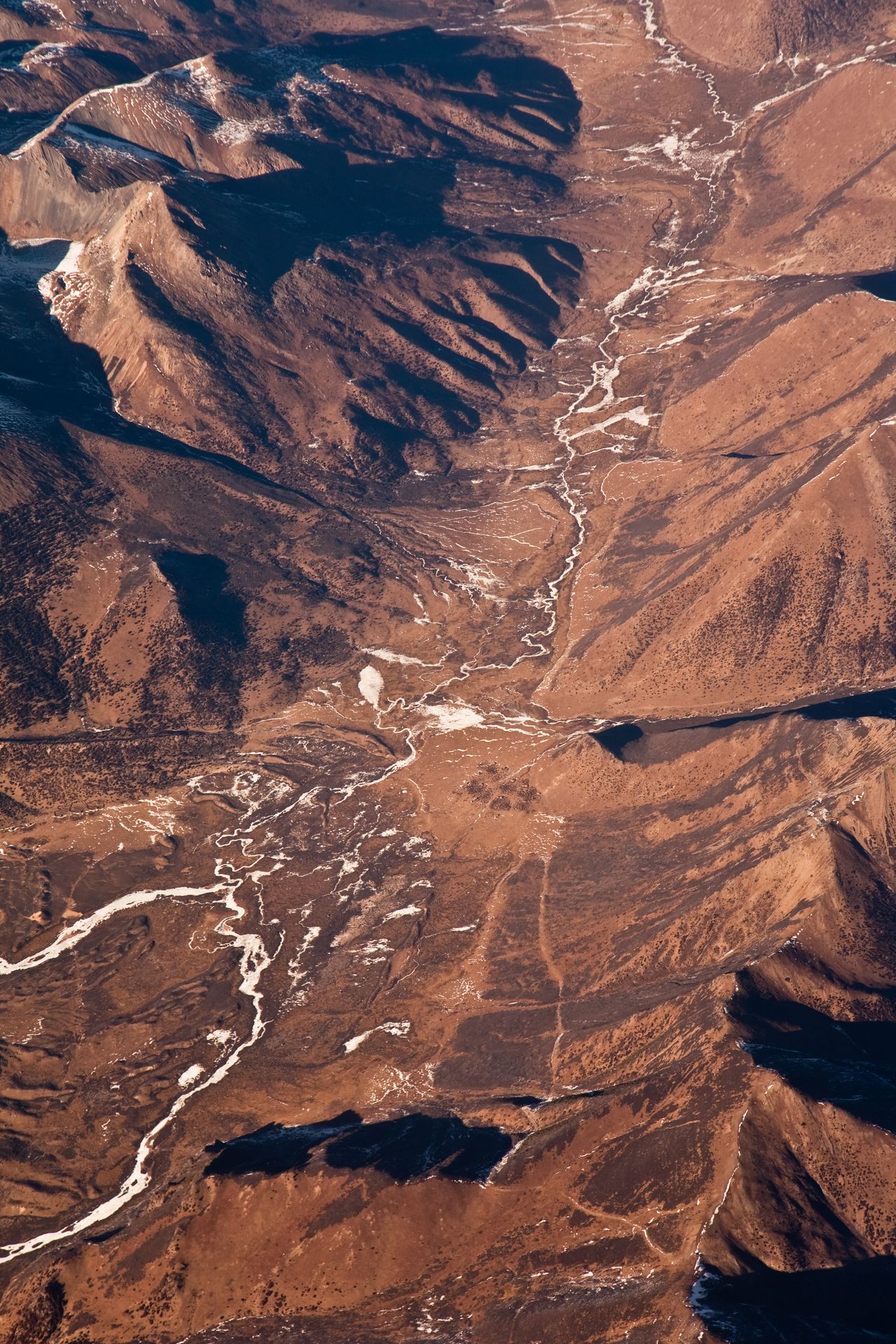 A series of rivers can be seen from an aerial view shot of a mountain range.