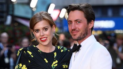 Princess Beatrice wears a black dress featuring yellow flowers and has red lipstick on, while her husband Edoardo Mapelli Mozzi wears a white tuxedo