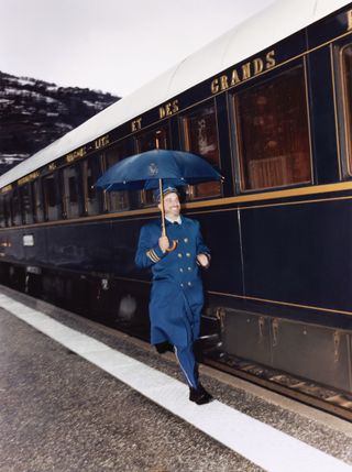 Orient Express and staff member in uniform with umbrella