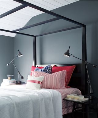 A bedroom painted blue with a canopy bed