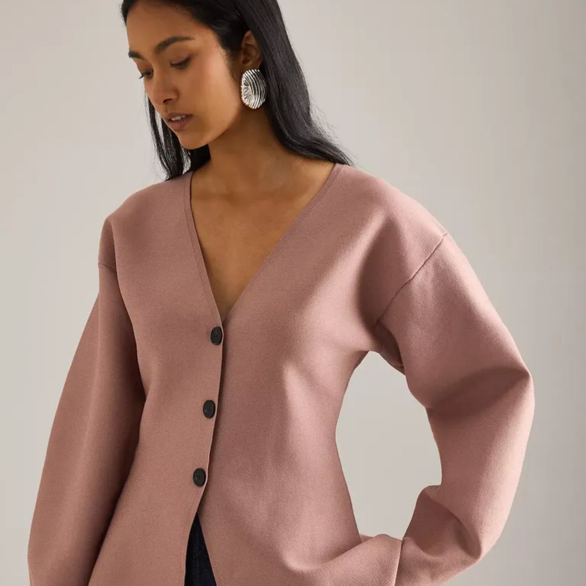 Woman wears pink fitted waist cardigan