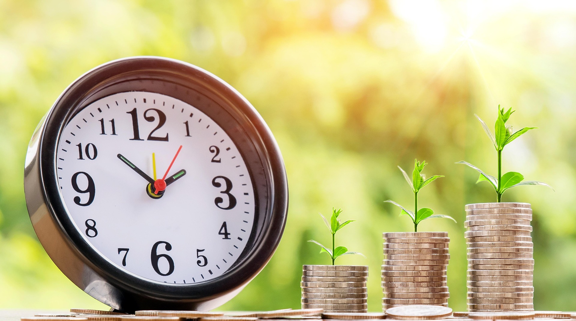 Clock next to coin stacks with plants growing