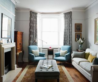 Living room with grey sofa, blue armchairs and trad fireplace