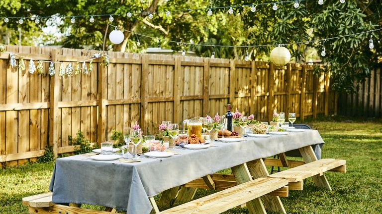 Fence types - wooden garden fence with outdoor table set up for a party