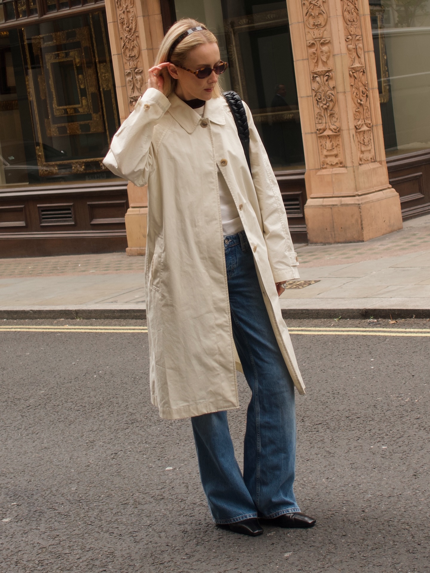 An image of @chloekathbutler wearing one of the biggest 2026 jeans trends, relaxed shapes, with a white t-shirt, white coat and square-toe jeans.