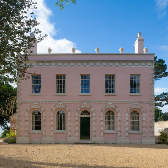 house exterior with pink walls and trees