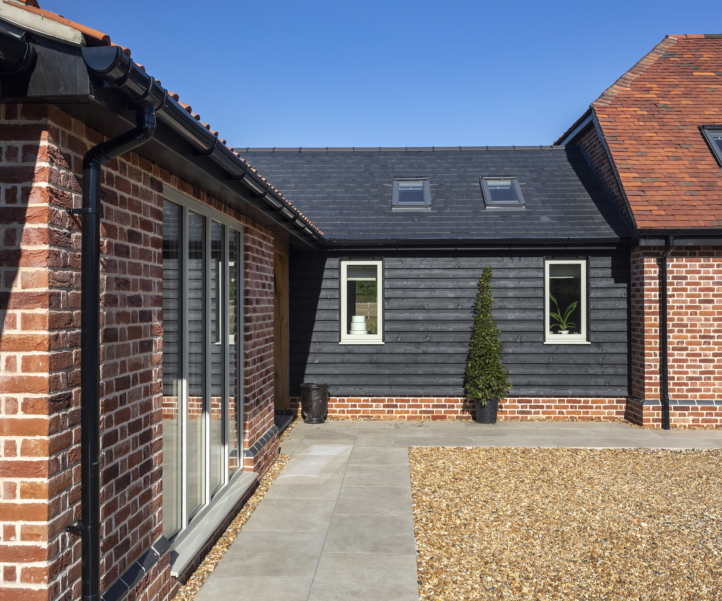 Side view of a pitched roof extension add on to a main converted barn home