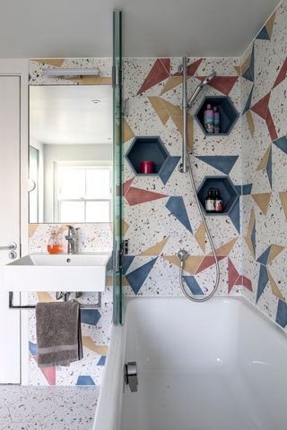 a bathroom with colorful tiles and hexagon shaped niches