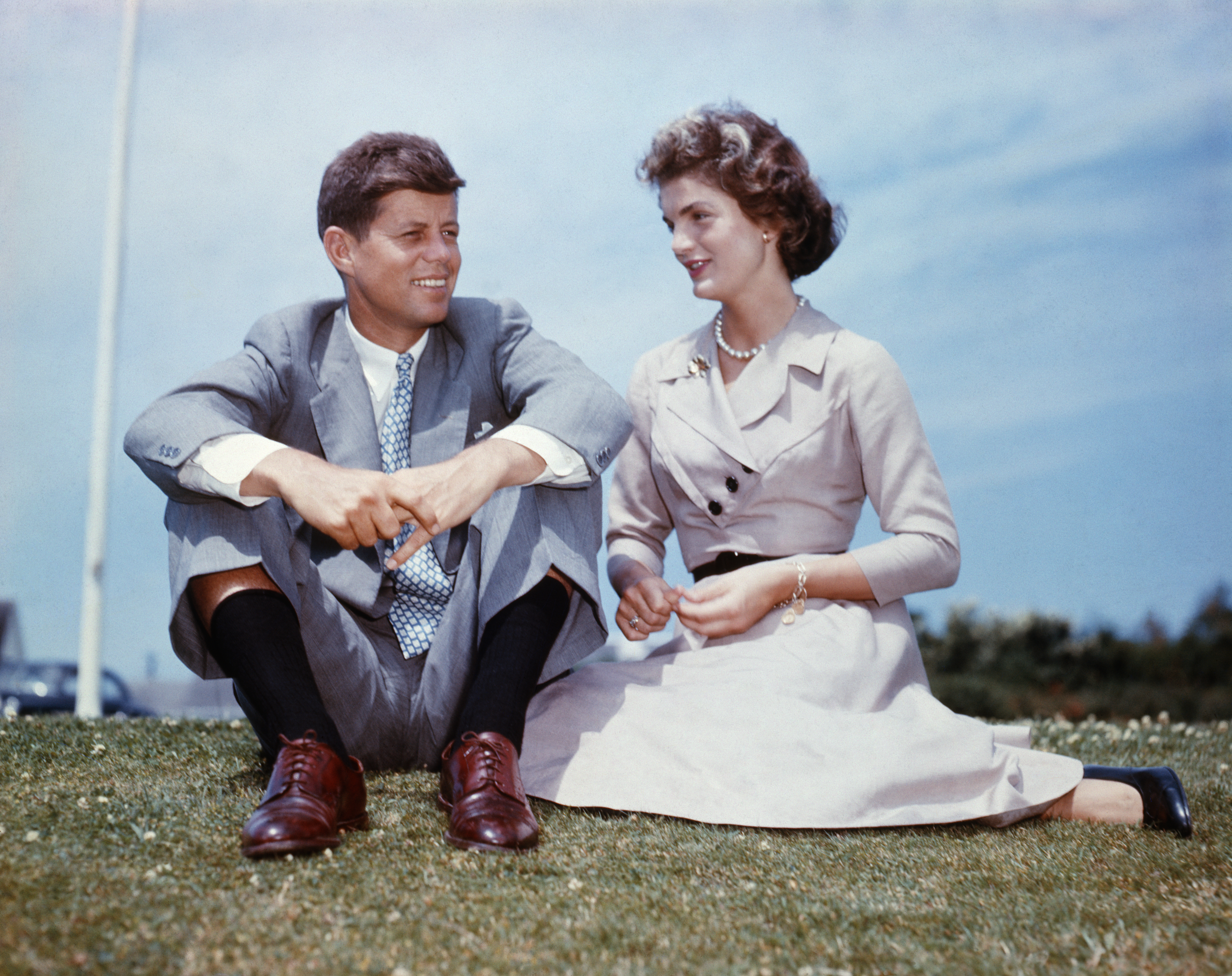 John F. Kennedy and Jacqueline Bouvier sit together in the sunshine at Kennedy&amp;amp;apos;s family home at Hyannis Port, Massachusetts, a few months before their wedding.