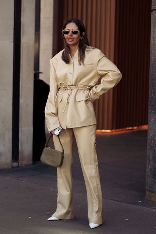 Woman in butter yellow leather suit GettyImages-2059614105