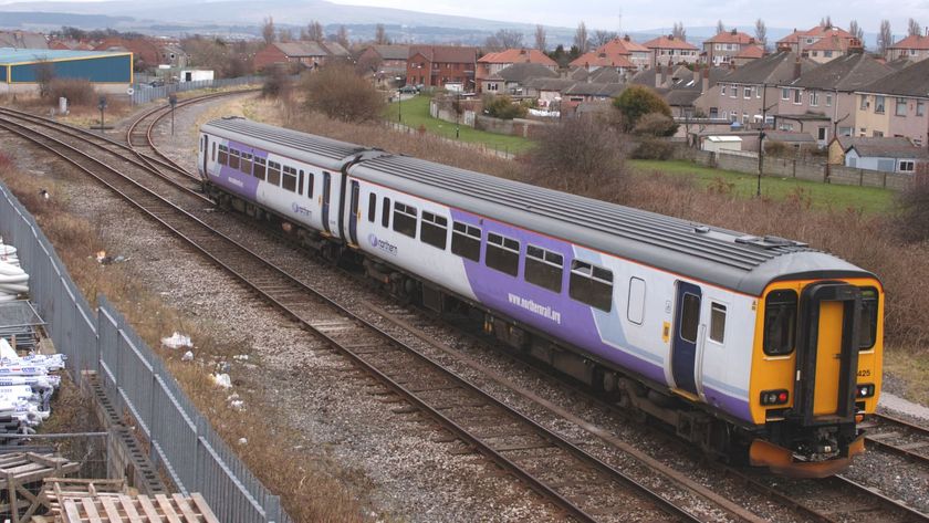 A train going past a row of houses