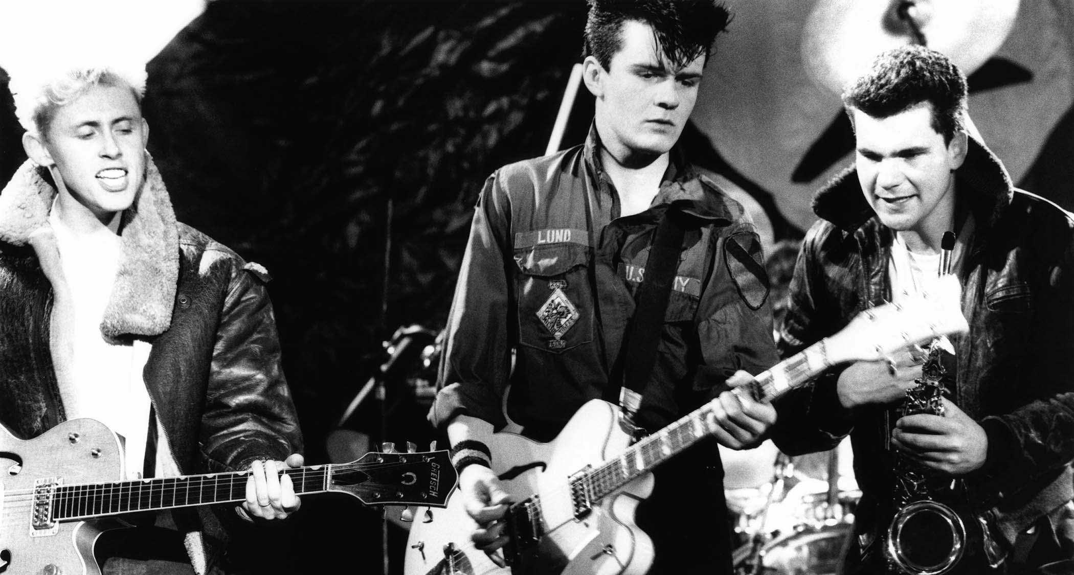 Billy Duffy (center) plays his double-cutaway Gretsch White Falcon with Theatre of Hate. Kirk Brandon is on the left, John Lennard on the right.