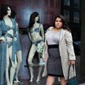 Plus-sized lady wearing a belt stood in front of mannequins 