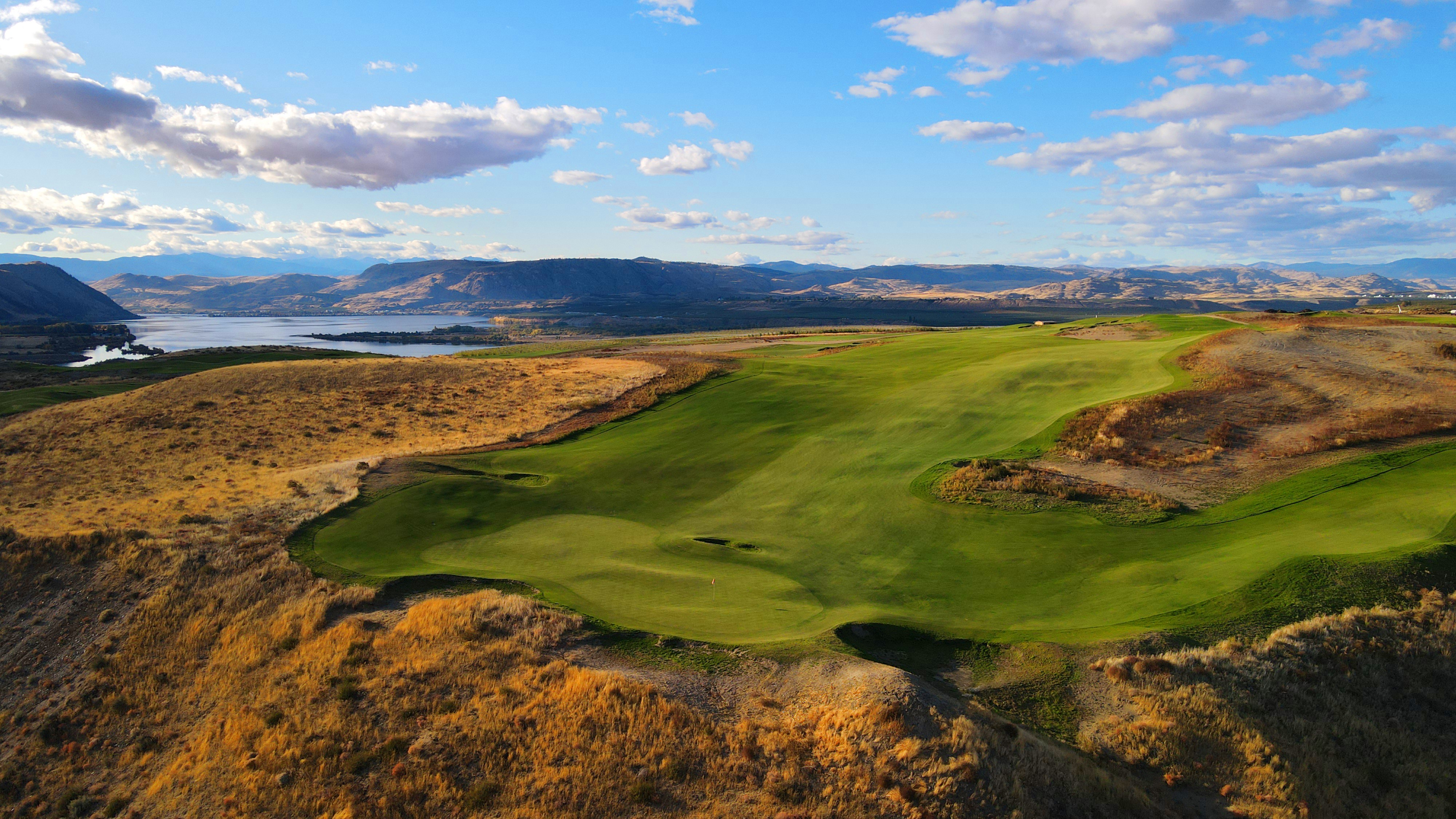 The Gamble Sands golf course with water and mountains in the background.