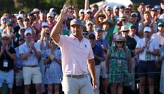 Bryson DeChambeau waves to the crowd after holing out