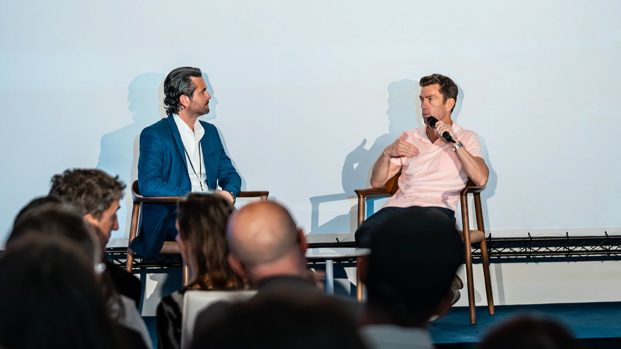 Two men conversing on stage at film awards event.