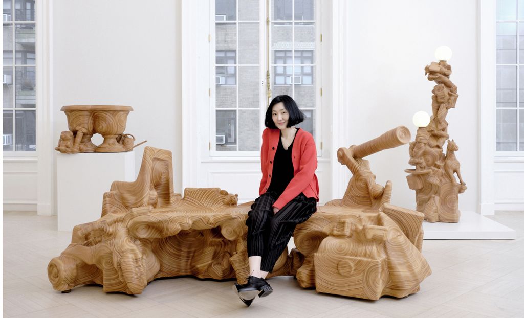 woman sits on leather-clad sculptures