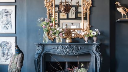 Black living room with gold mirror above the mantel