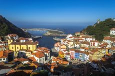 Panoramic view of Cudillero, in Asurias, Spain. The houses are painted with cheerful colors. They seem to descend from the mountain towards the sea. 