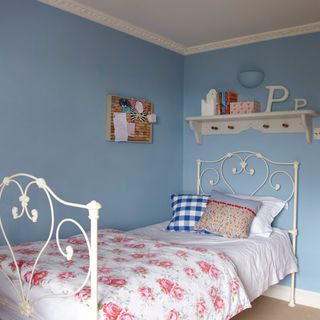 girls bedroom with single bed and peg rail shelf