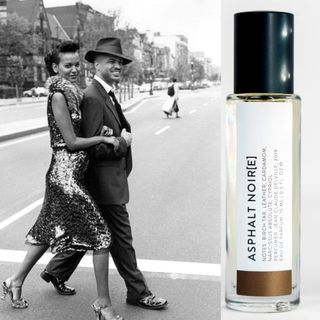 Man and Woman in smart clothing walking over a road next to Asphalt Noire perfume