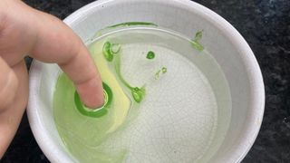 Finger dipped in a water bowl to make marble nails