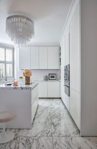 an all white kitchen with marble worktops