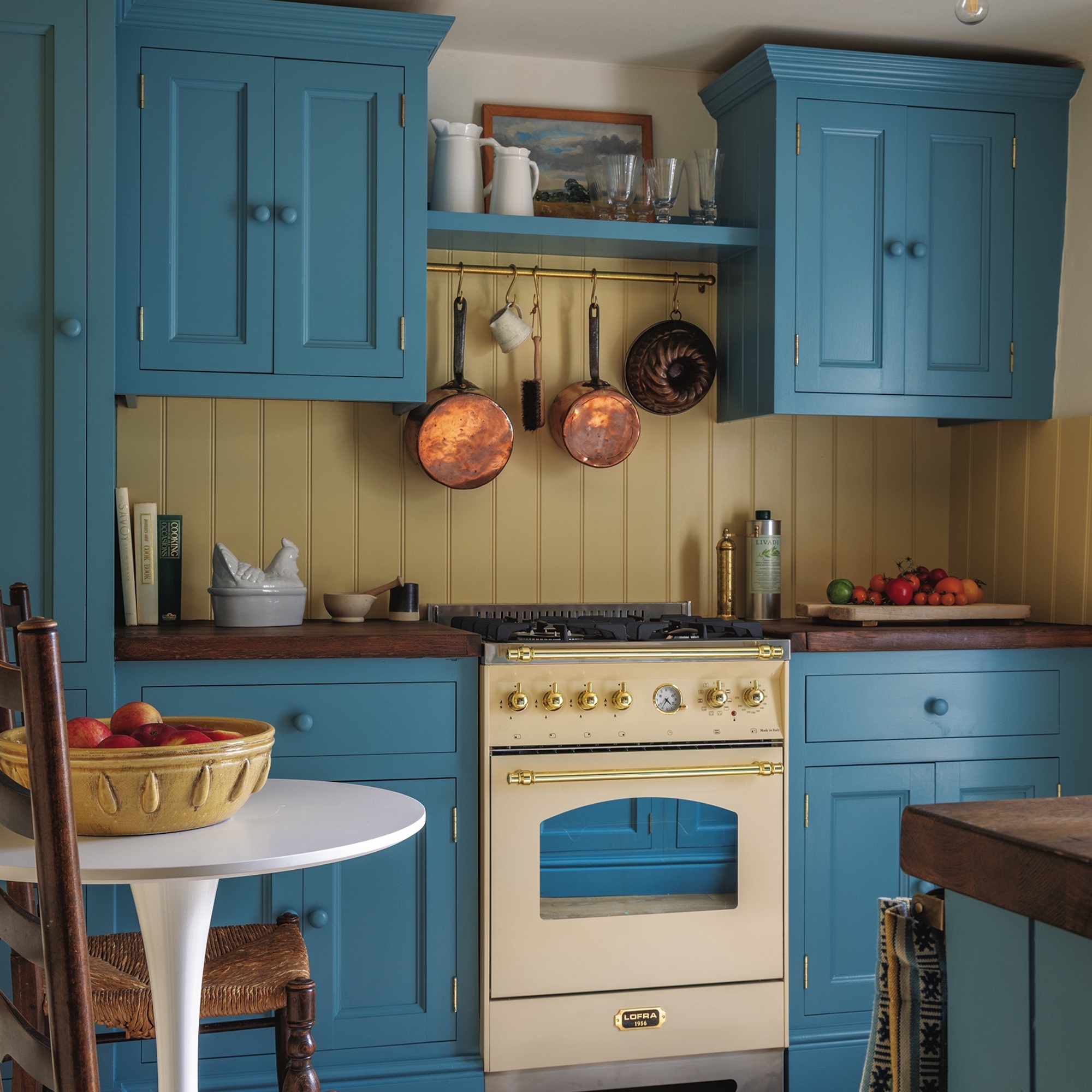 kitchen with midblue painted shaker cabinets and cream coloured range cooker