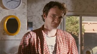Quentin Tarantino in a robe, standing in a kitchen in Pulp Fiction. 