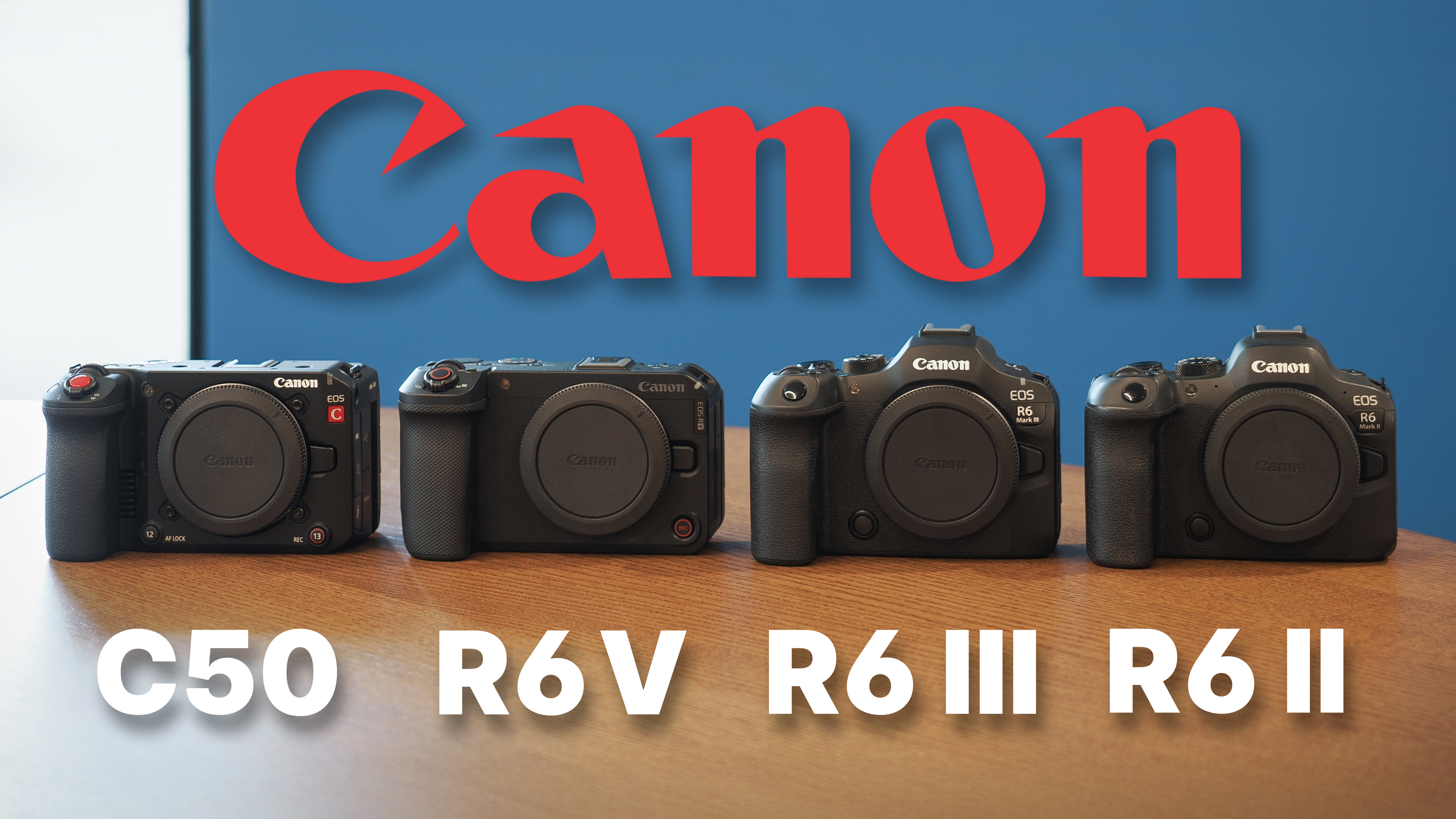 The Canon EOS C50 next to the EOS R6 V, R6 Mark III and R6 Mark II, on a wooden surface against a blue background